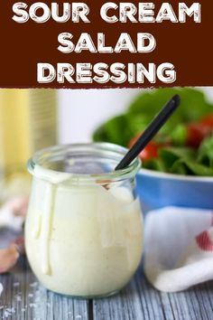 a jar filled with dressing next to a bowl of salad