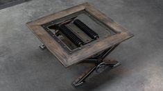 a square table with wheels on the bottom and an open hole in the middle that has springs attached to it