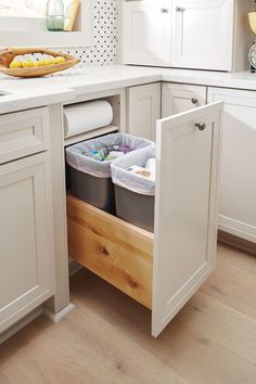 an open cabinet in a kitchen filled with plastic containers