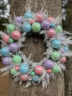 a wreath made out of frosted branches and eggs on top of it next to a tree