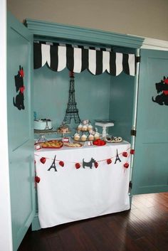 a table with desserts on it in front of the eiffel tower door