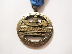 a medal with a blue ribbon around it on a white surface, that says madison