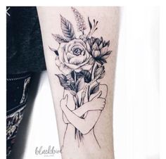 a black and white photo of a woman's arm with flowers on it,