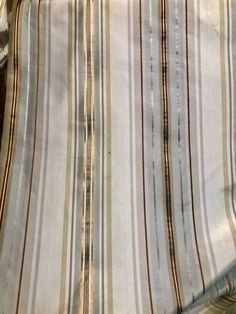 a close up view of a bed with striped sheets