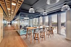 an office with large windows and wooden flooring in the center, along with lots of chairs