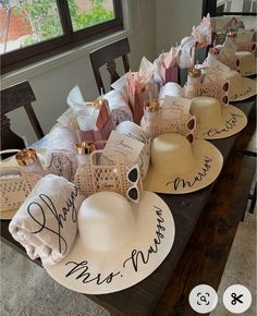 several hats are lined up on a table with the names of people and their families