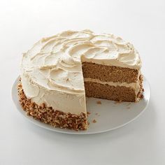 a cake with white frosting is on a plate and has one slice cut out