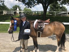 a woman standing next to a brown horse