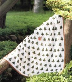 a white and green blanket hanging from a tree