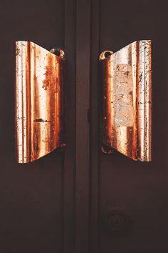 an old door with two metal plates on it's side and one has a hole in the middle