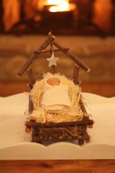 a nativity scene made out of twigs and wood with a baby in a manger