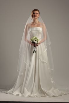 a woman in a wedding dress holding a bouquet