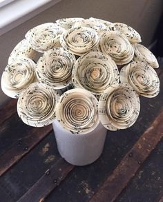 a white vase filled with lots of paper flowers