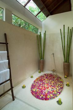 the bathroom is decorated with colorful flowers and bamboo sticks in vases on the floor