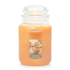 an orange candle is sitting on a white surface