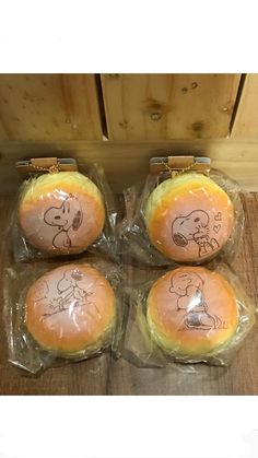 four bagels wrapped in plastic with drawings on them