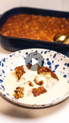 a blue and white bowl filled with food next to a baking pan full of baked goods