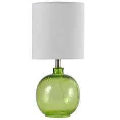 a green glass table lamp with a white shade on the base and a white fabric lampshade