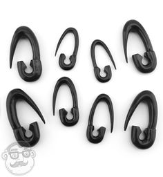 six pairs of black plastic hooks on a white background