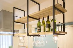 a kitchen filled with lots of wine bottles and glasses on top of shelves above the stove