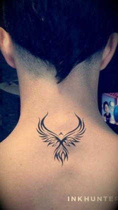 the back of a woman's neck with a bird tattoo on it