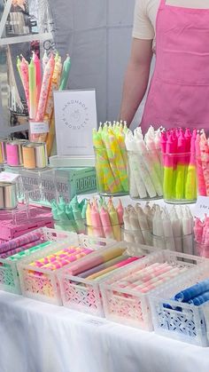 there are many different types of pens on display at this market table, including one with an apron