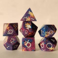 the purple and blue marbled dice has numbers on each side, as well as two smaller ones