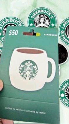 someone holding up a starbucks gift card with stickers on it