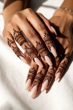 a woman's hands with henna tattoos on them