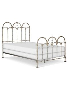 a metal bed frame with white sheets and pillows on it's headboard, against a white background