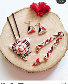 the beaded jewelry is displayed on a piece of wood with a red tassel