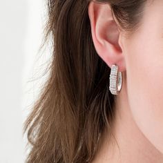 A contemporary classic, these diamond hoop earrings pair well with most any attire. Created in sterling silver, each sophisticated hoop features three rows of sparkling round diamonds. A pair of collars lined with channel-set baguette-cut diamonds adds interest to the style. Radiant with 1 ct. t.w. of diamonds and a brilliant buffed luster, these earrings secure with hinged backs. Baguette Cut Diamond, Contemporary Classic, Diamond Hoop Earrings, Channel Set, Baguette Cut, Diamond Stone, Earring Backs, White Metal, Sterling Earrings