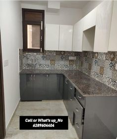 an empty kitchen with white cabinets and grey counter tops