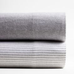 two gray and white striped sheets folded on top of each other in front of a white background