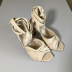 This Luxurious Leather Sandal Topped With Wraparound Ankle Straps Is Raised On A Tall, Sculptural Heel That Brings Individuality To Your Ensembles. Ankle Tie Closure And Made From Linen And Leather. Heel Height: 3.9 Inches. Size 7. New With Tags And In Box. Elegant Open Toe Lace-up Sandals With Strap, Beige High Heel Sandals With 4-inch Heel, Elegant Open Toe Lace-up Sandals With Removable Insole, Beige Ankle Strap Heels With 4-inch Heel, Beige Leather Lace-up Sandals With Round Toe, Beige Closed Toe Sandals With Heel Strap, Cream Open Toe Sandals With 4-inch Heel, Beige Closed Toe Sandals For Party, Elegant Spring Lace-up Sandals With Removable Insole