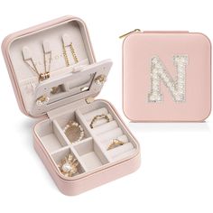 a pink case with jewelry in it and a letter n on the inside is shown