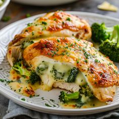 a white plate topped with chicken covered in cheese and broccoli next to a bowl