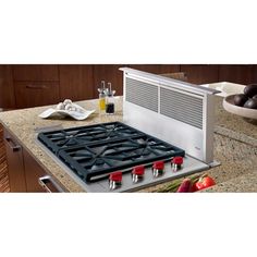 a stove top oven sitting on top of a counter next to a bowl of fruit