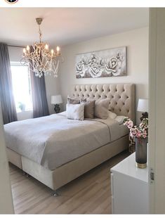 a bedroom with a bed, chandelier and two lamps on either side of the bed