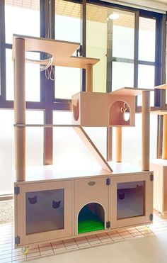 the cat house is made out of cardboard and has multiple shelves for cats to play in