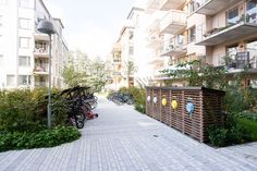 several bicycles are parked on the sidewalk in front of an apartment building