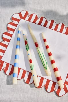 three candles sitting on top of a red and white paper plate next to each other