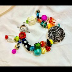 an assortment of colorful beads and charms on a white sheet