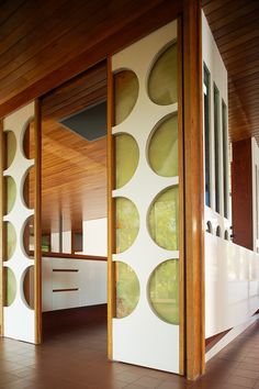 an open room with wooden floors and white walls, decorated with green circles on the wall