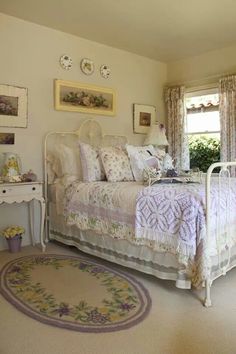 a white bed sitting in a bedroom next to a rug on top of a floor