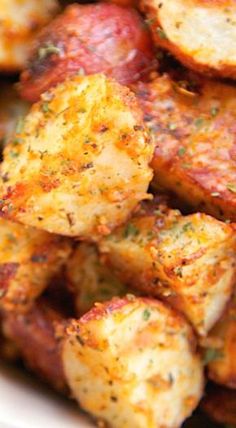 close up view of cooked potatoes with seasoning on them in a white bowl, ready to be eaten