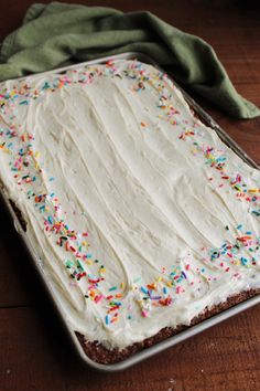 a sheet cake with white frosting and sprinkles