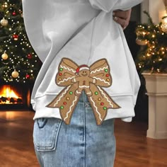 a woman wearing a white sweatshirt with gingerbread cookies on it's back pocket