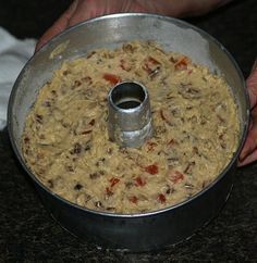 a person holding a metal pan filled with food