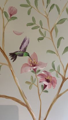 a painting of a hummingbird and pink flowers on a tree branch with green leaves